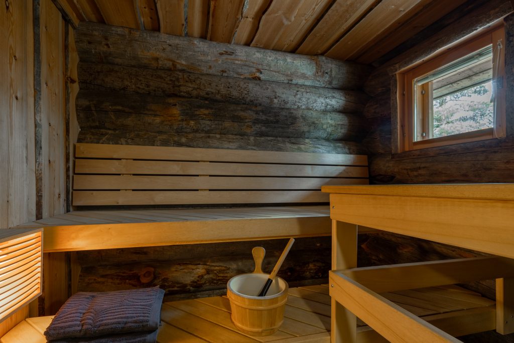 Perinteinen suomalainen sauna, jossa puiset seinät, lauteet ja katto.