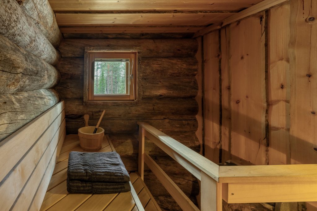 Perinteinen suomalainen sauna, jossa puiset seinät, lauteet ja katto.
