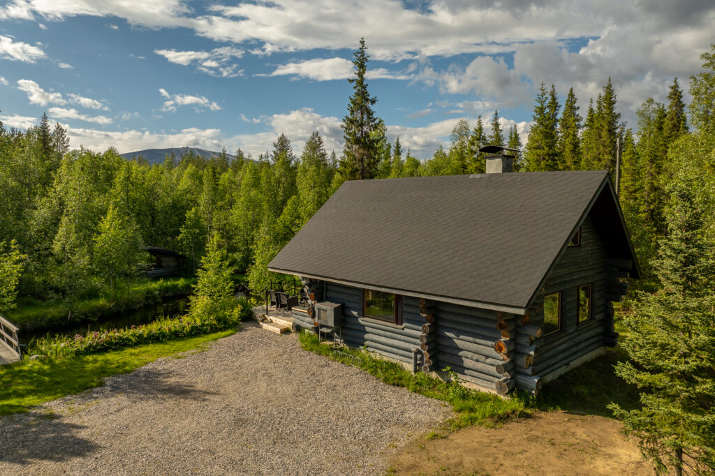 Mökki metsän keskellä, kaunis maisema taustalla.