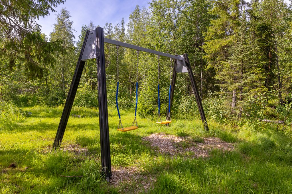 Keinu ulkona vihreän metsän keskellä Ylläksellä. Ylläs mökit, Yllas cabins, vuokramökit sivustolta